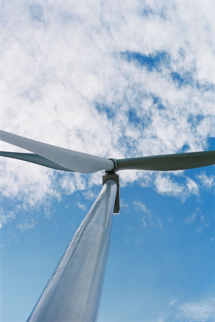 Mastering the First Impression: Your intriguing post title goes here Looking up at a wind turbine with a backdrop of a clear blue sky, symbolizing renewable energy.